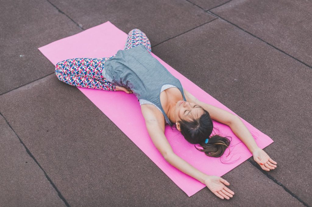 Crafting Captivating Headlines: Your awesome post title goes here Woman performing yoga stretch on a pink mat outdoors. Promotes fitness and relaxation.